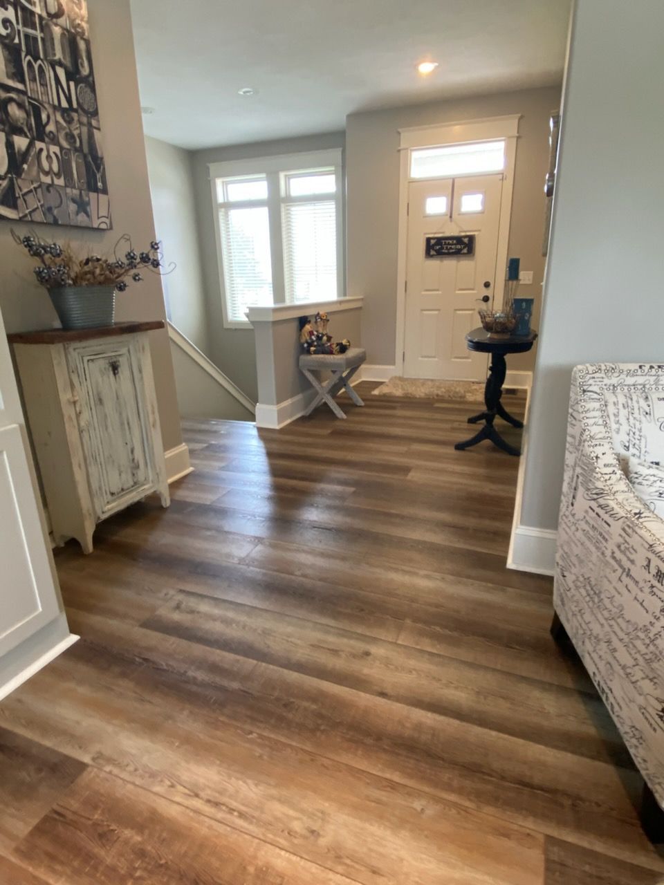 Home entryway with wood floors, white door, and light-filled windows