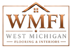 WMFI logo in copper and gray with a house roof, reading &ldquo;West Michigan Flooring & Interiors&rdquo;