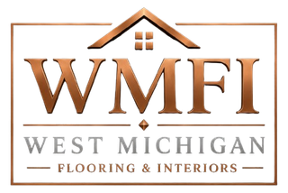WMFI logo in copper and gray with a house roof, reading &ldquo;West Michigan Flooring & Interiors&rdquo;
