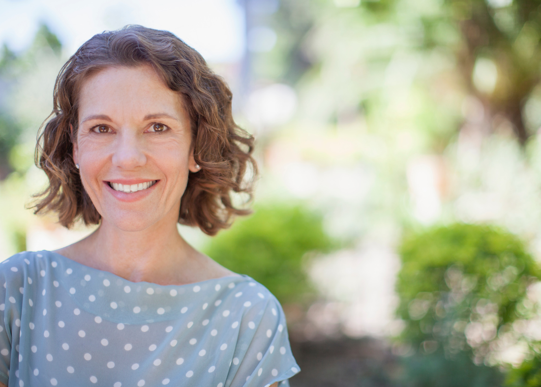 Smiling middle-aged woman outdoors in natural light