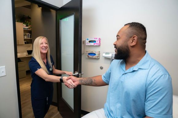 Cora Mattie greeting a patient at the clinic entrance