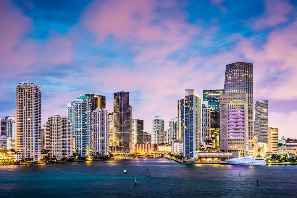 A city skyline overlooking a body of water at night.