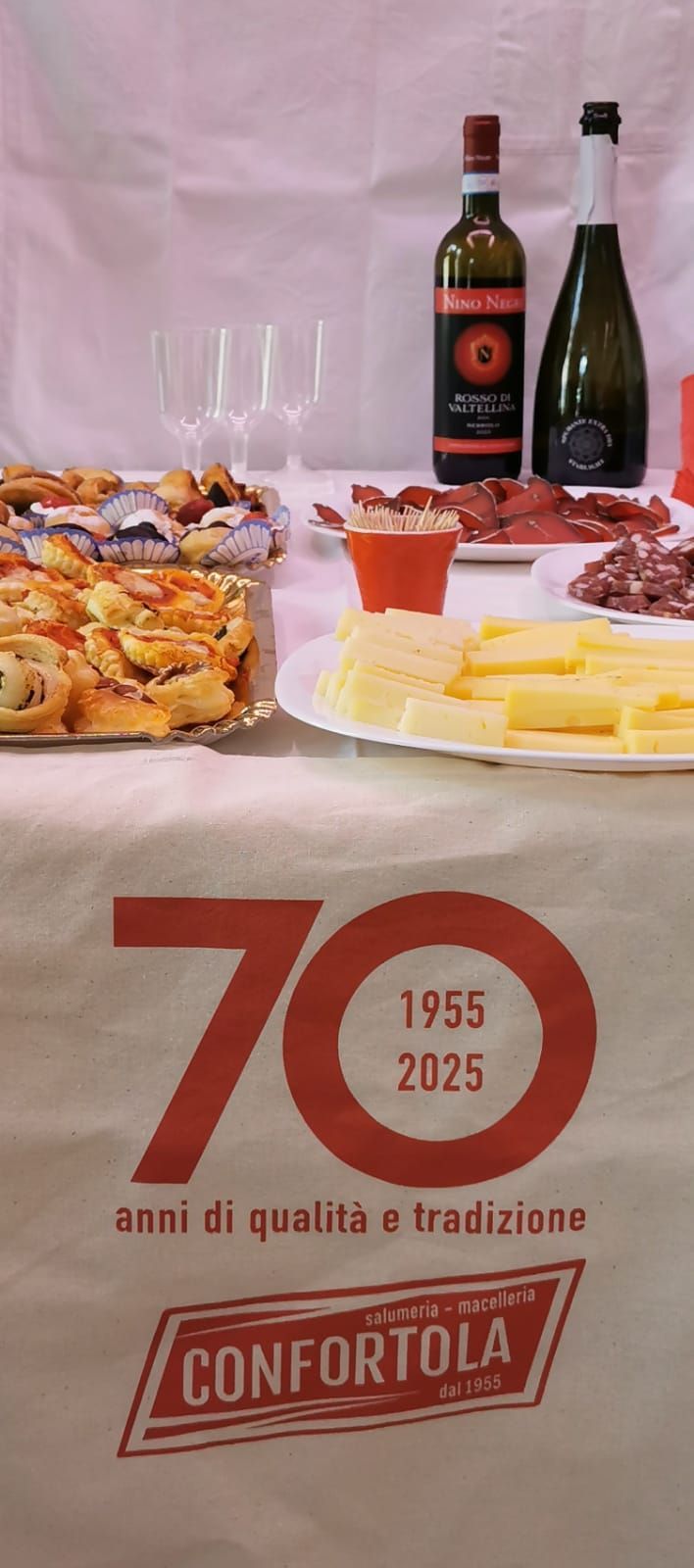 Un tavolo sormontato da piatti di cibo e bottiglie di vino.
