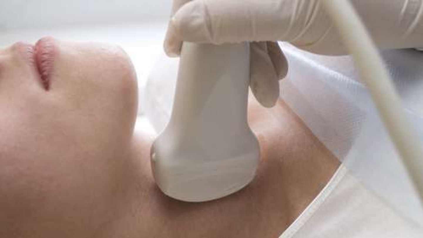 Ultrasound probe scanning a patient’s neck during a medical exam