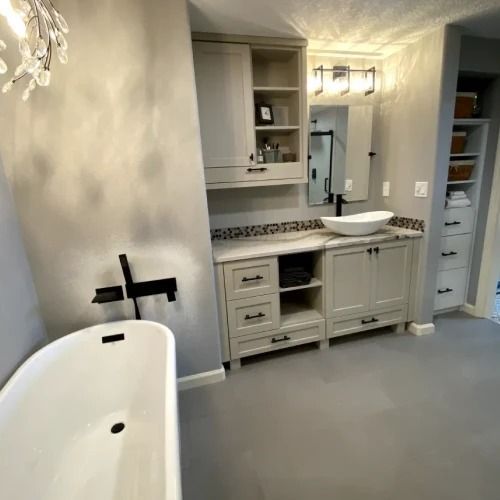 Modern bathroom with freestanding tub, double vanity, mirror, and gray walls