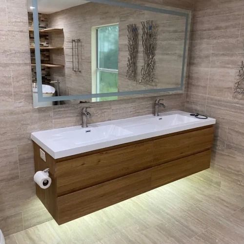 Modern bathroom with wood vanity, double sinks, large mirror, and soft under-cabinet lighting
