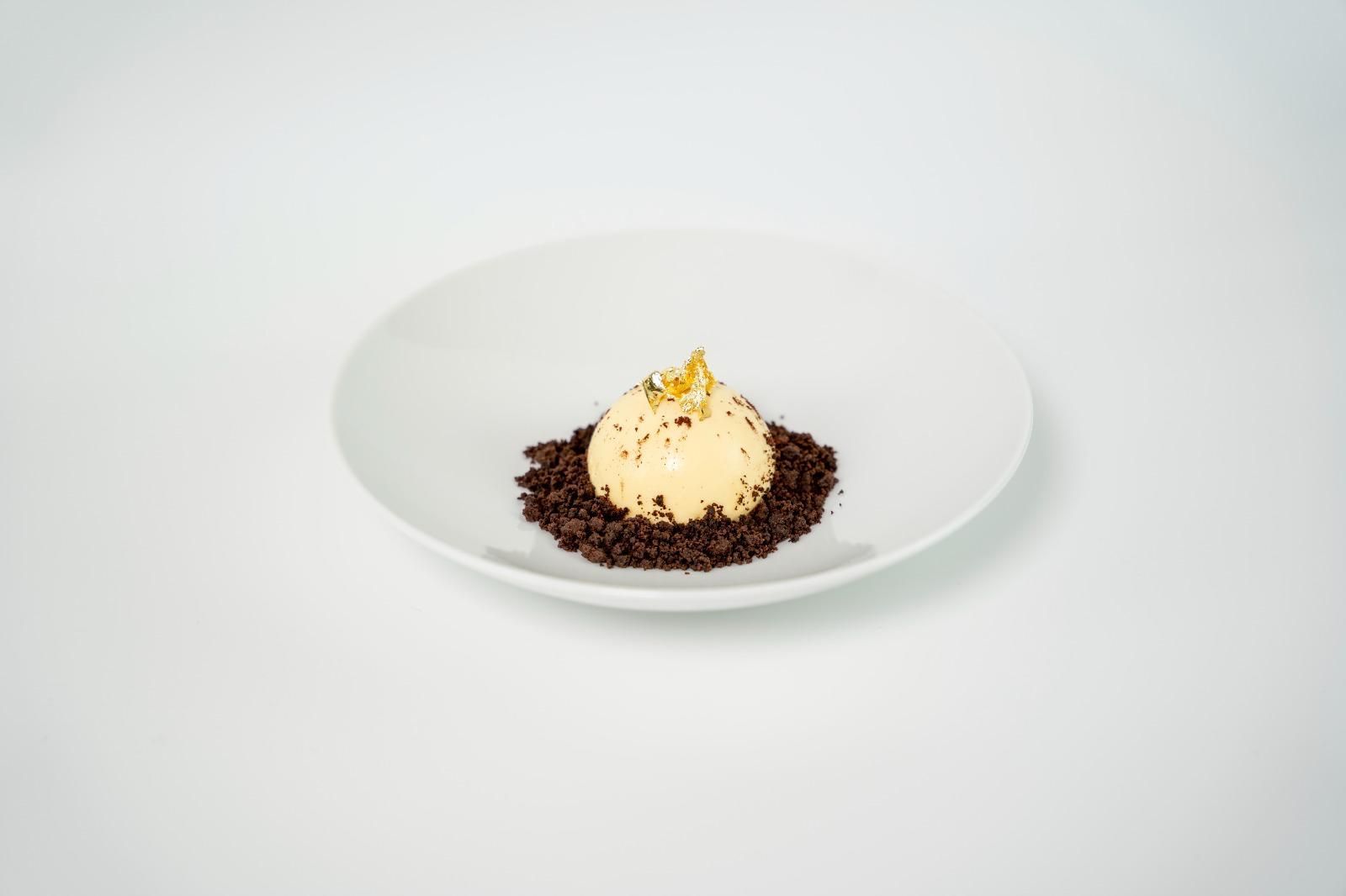 Dessert alla vaniglia con briciole di cioccolato su un piatto bianco, su uno sfondo chiaro