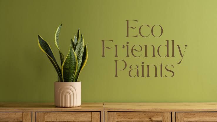 Green wall with a potted snake plant on a wooden shelf and the words “Eco Friendly Paints.”