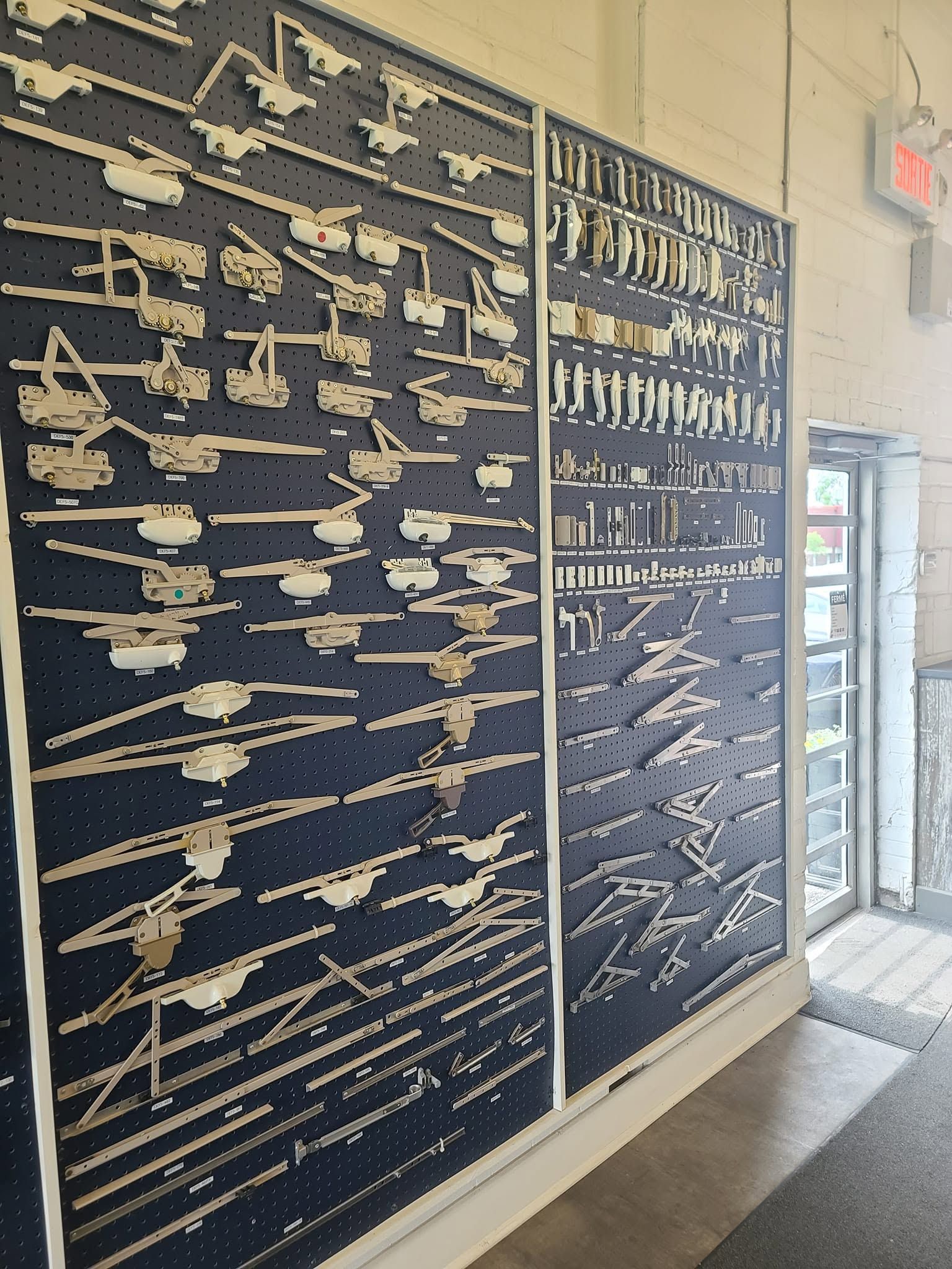 Wall display of numerous mounted firearms and rifles in a museum-like exhibit indoors