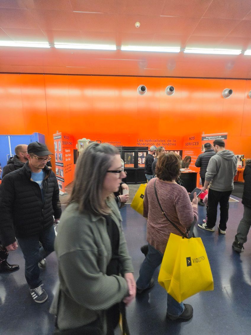 People browsing in a store with a bright orange wall and a yellow shopping bag in the foreground