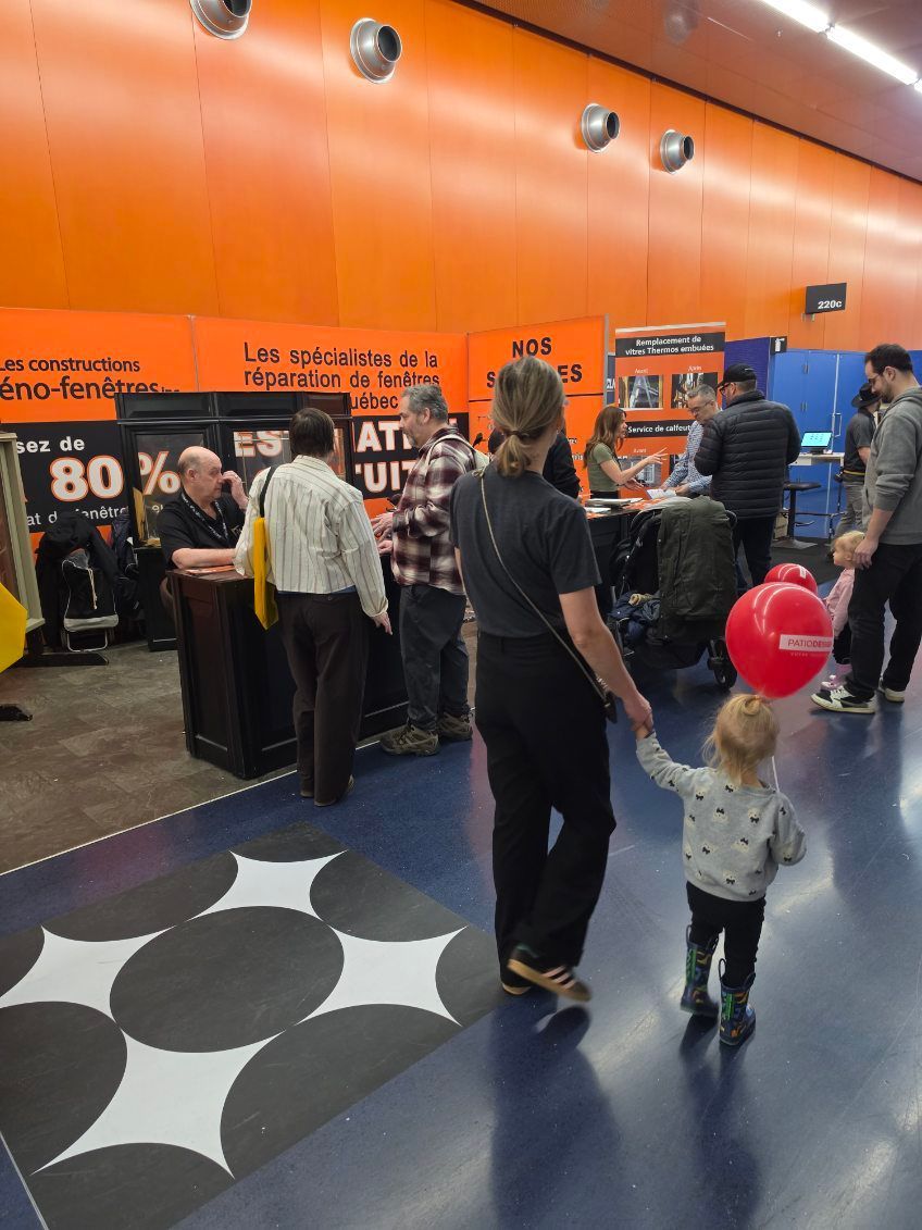 People browsing a store with orange walls and shelves, a child holding a red balloon in the foreground