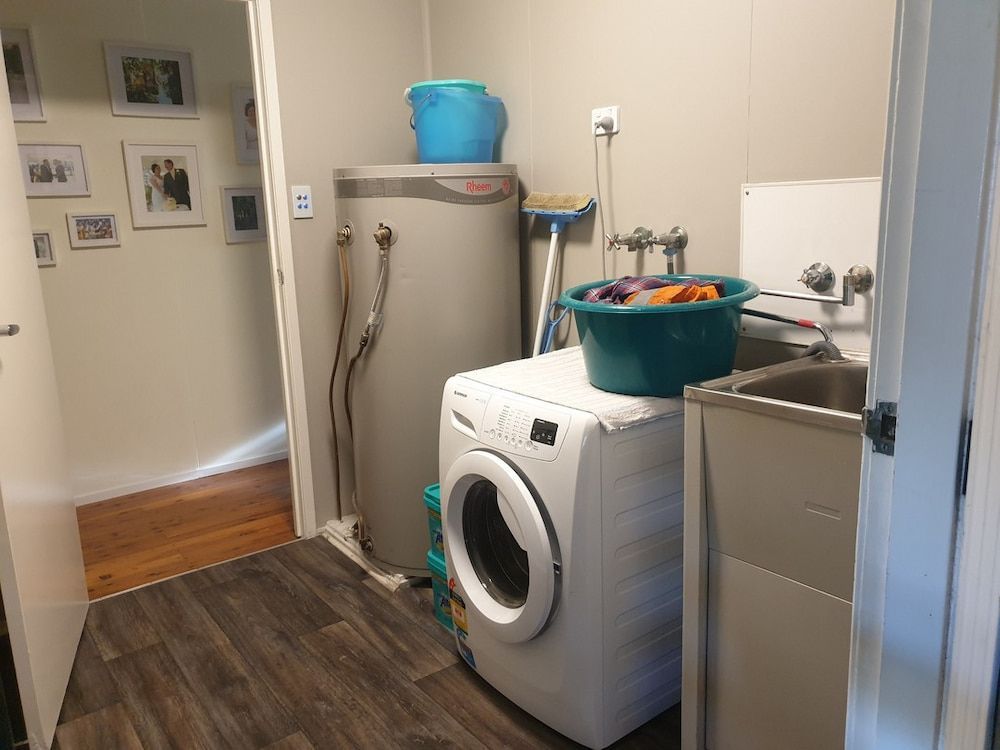 A Laundry Room With A Washer And Dryer And A Sink — Pioneer Cabinets in Rural View, QLD