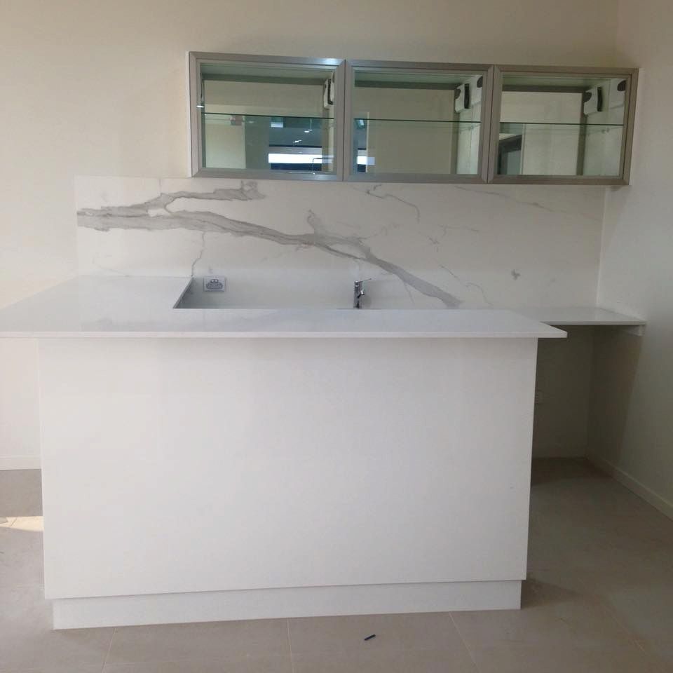 A Kitchen With A Sink, Cabinets And A Marble Countertop — Pioneer Cabinets in Paget, QLD