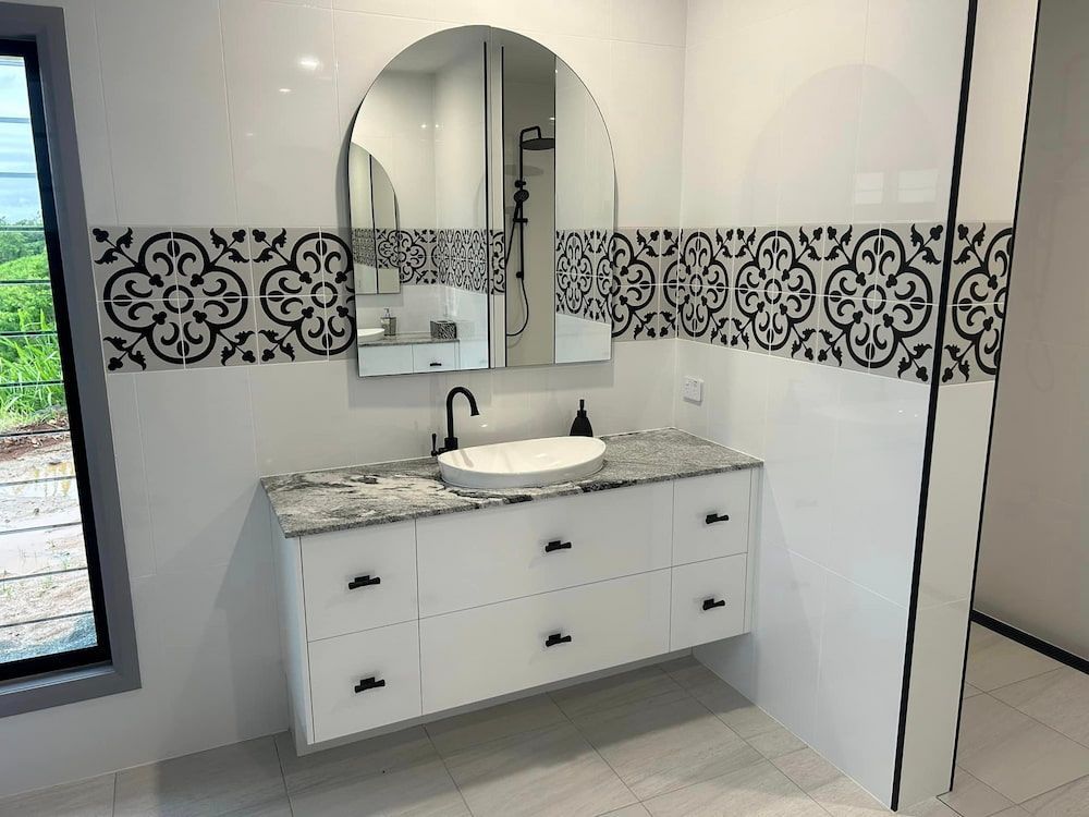 A Bathroom With A Sink, Mirror, And Drawers — Pioneer Cabinets in Paget, QLD