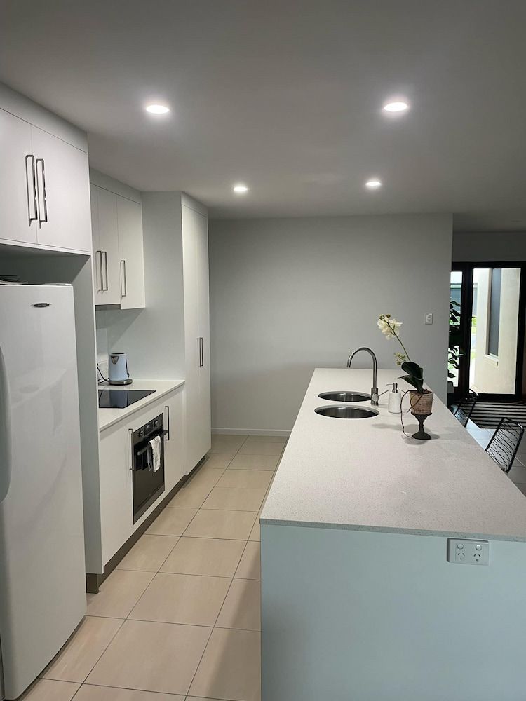 A Kitchen With White Cabinets And A Large Island — Pioneer Cabinets in Rural View, QLD