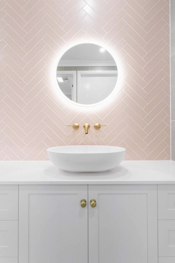 A Bathroom With A Sink, Mirror And Pink Tiles — Pioneer Cabinets in Sarina, QLD