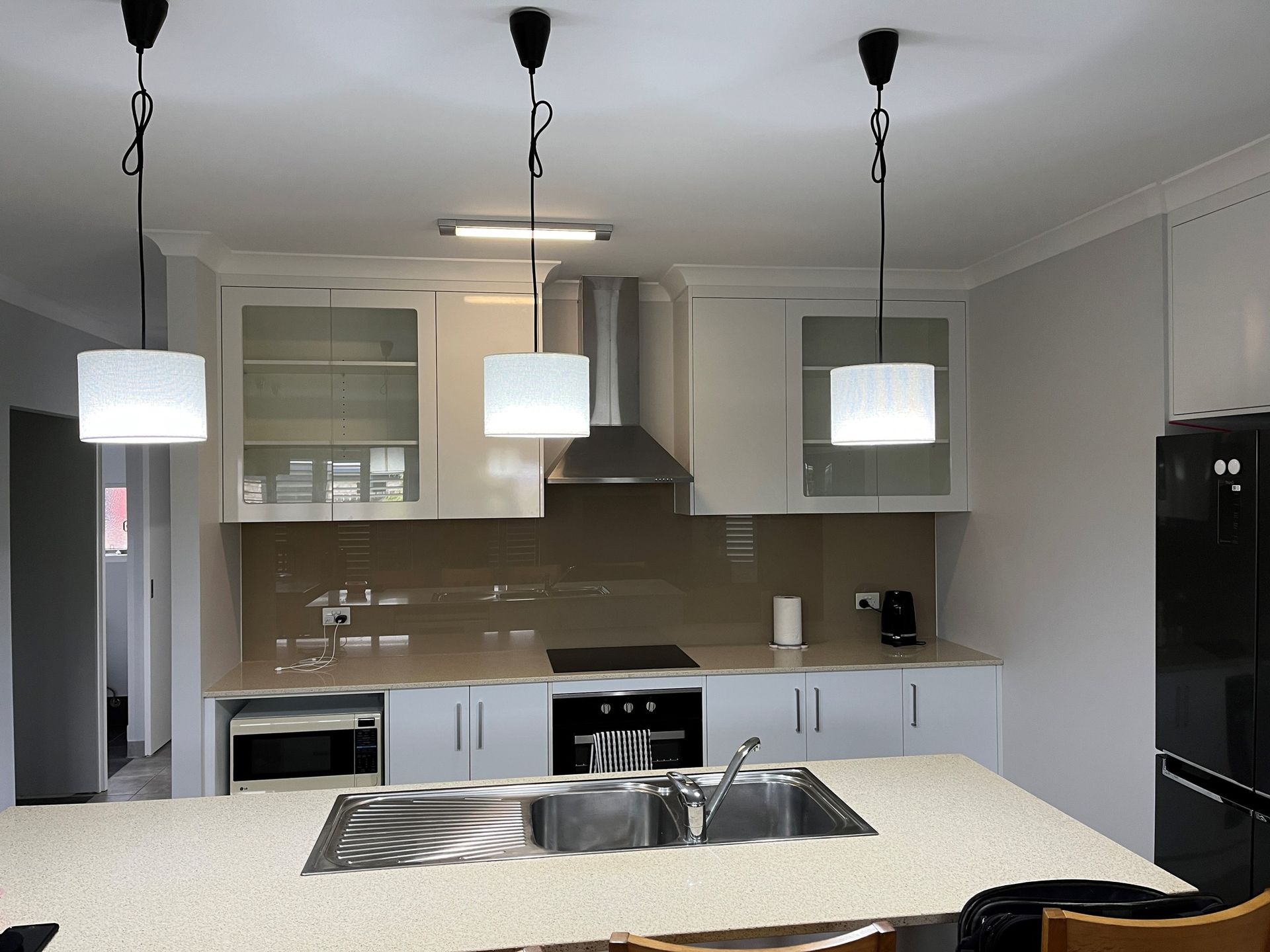 A Kitchen With A Vase Of Yellow Roses On The Counter — Pioneer Cabinets in Paget, QLD