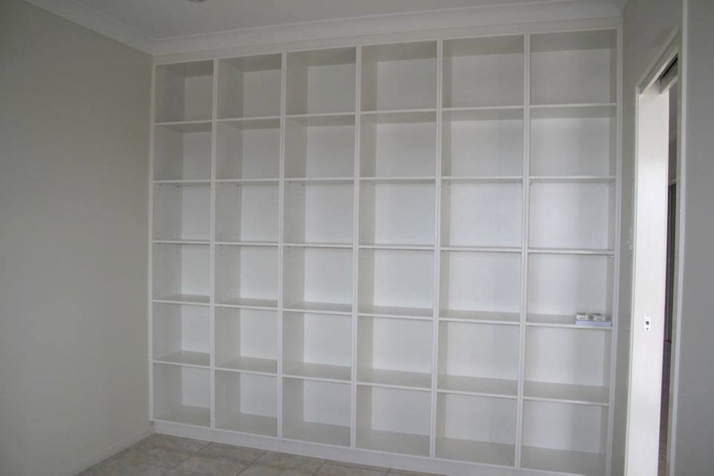 A Room With A Wall Of White Shelves And A Door — Pioneer Cabinets in Airlie Beach, QLD