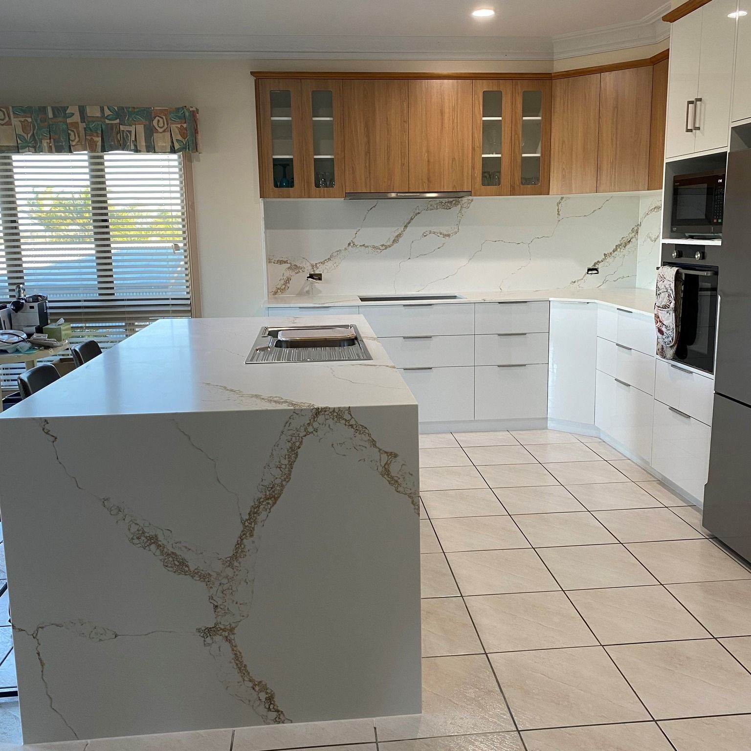 A Kitchen With Stools And A Clock On The Wall — Pioneer Cabinets in Paget, QLD