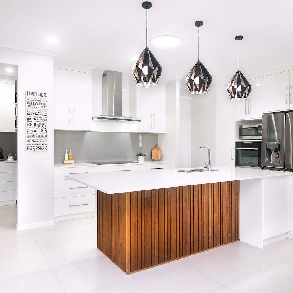 A Kitchen With White Cabinets And A Wooden Island — Pioneer Cabinets in Airlie Beach, QLD