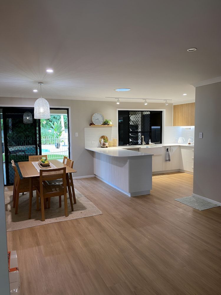 There Is A Dining Table And Chairs In The Middle Of The Room — Pioneer Cabinets in Sarina, QLD
