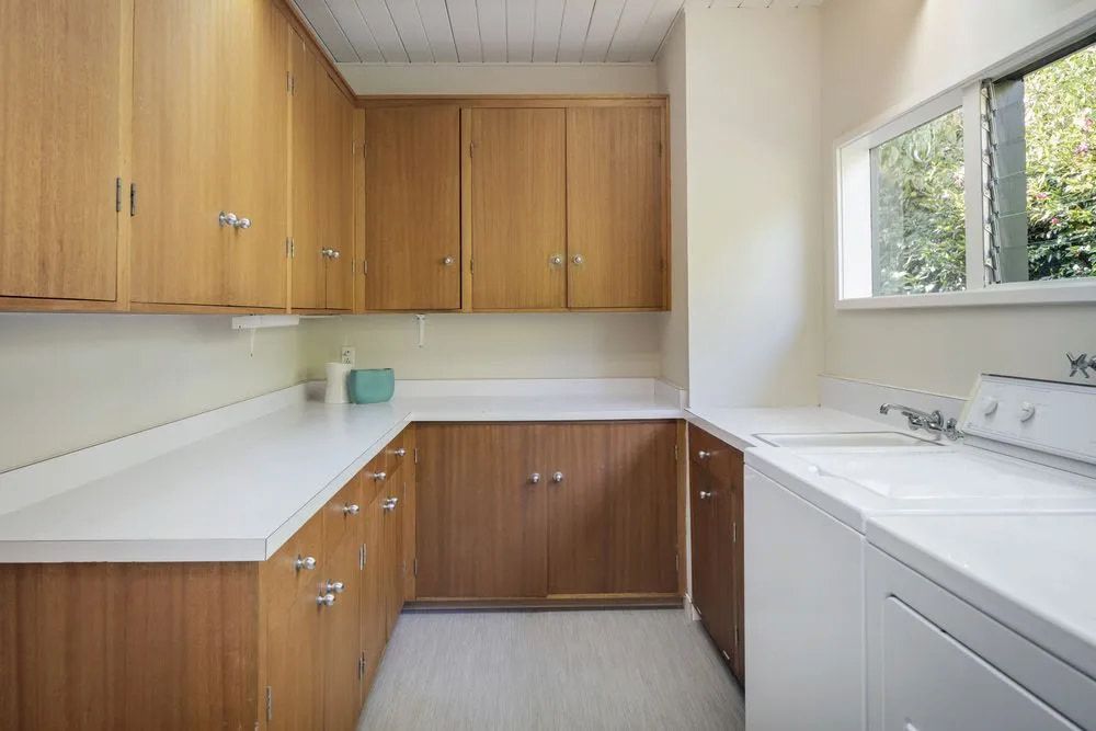 A Laundry Room With A Washer And Dryer And Wooden Cabinets — Pioneer Cabinets in Paget, QLD