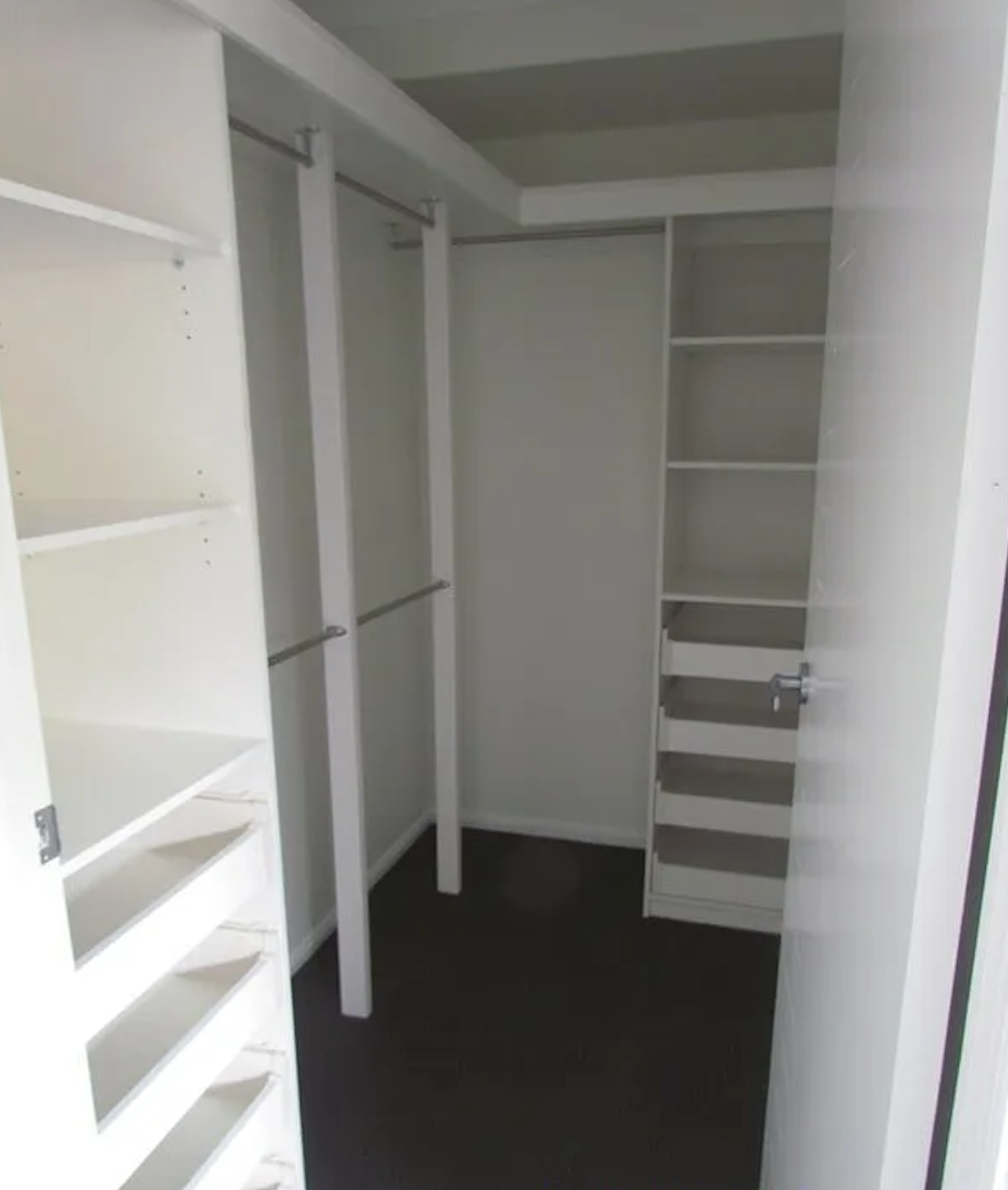 A Walk In Pantry With White Shelves And A Wooden Table — Pioneer Cabinets in Paget, QLD