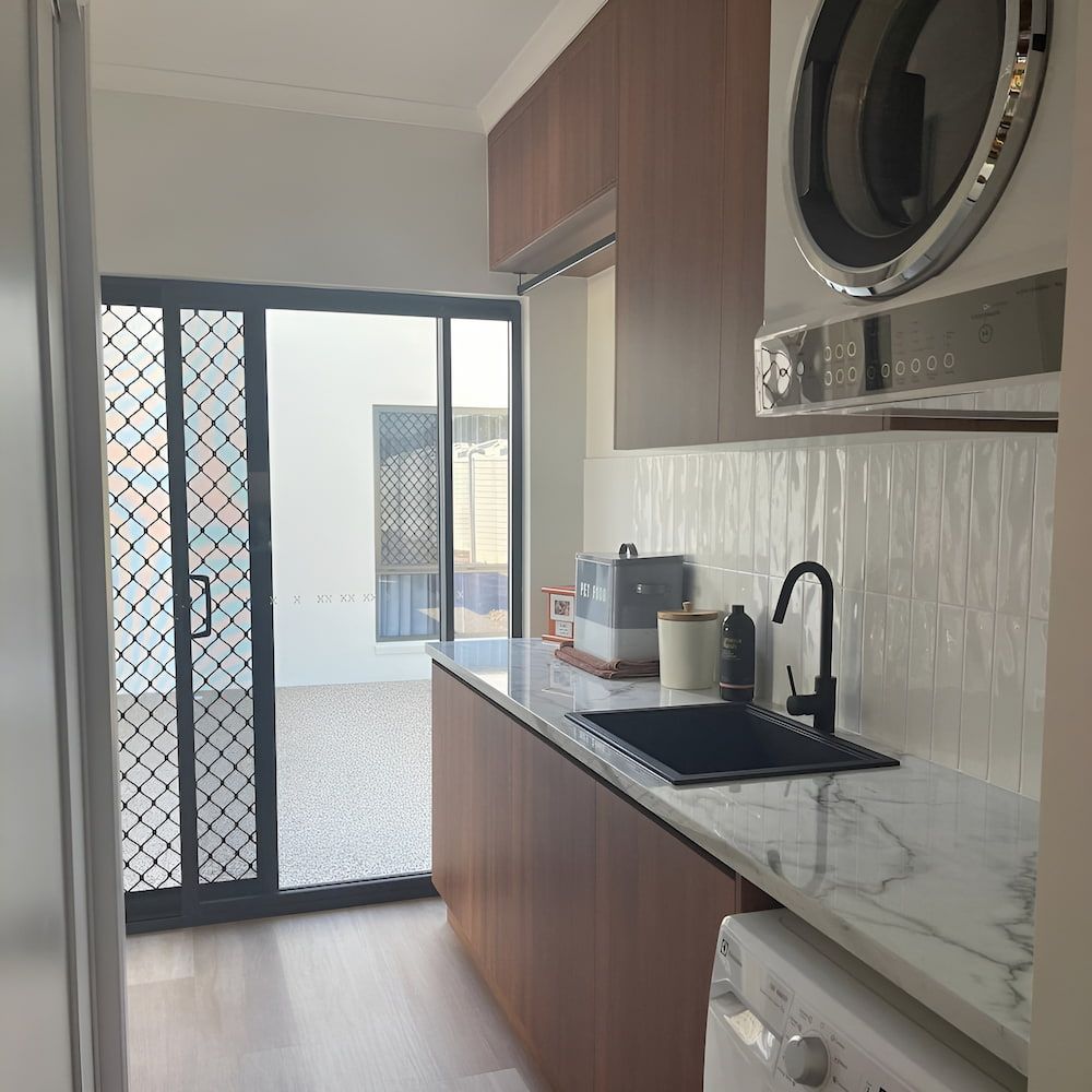 A Kitchen With A Sink And A Washer And Dryer — Pioneer Cabinets in Rural View, QLD