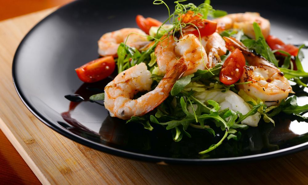 Shrimp Salad on A Black Plate and A Wooden Cutting Board — Mount Louisa Snack Bar in Mount Louisa, QLD