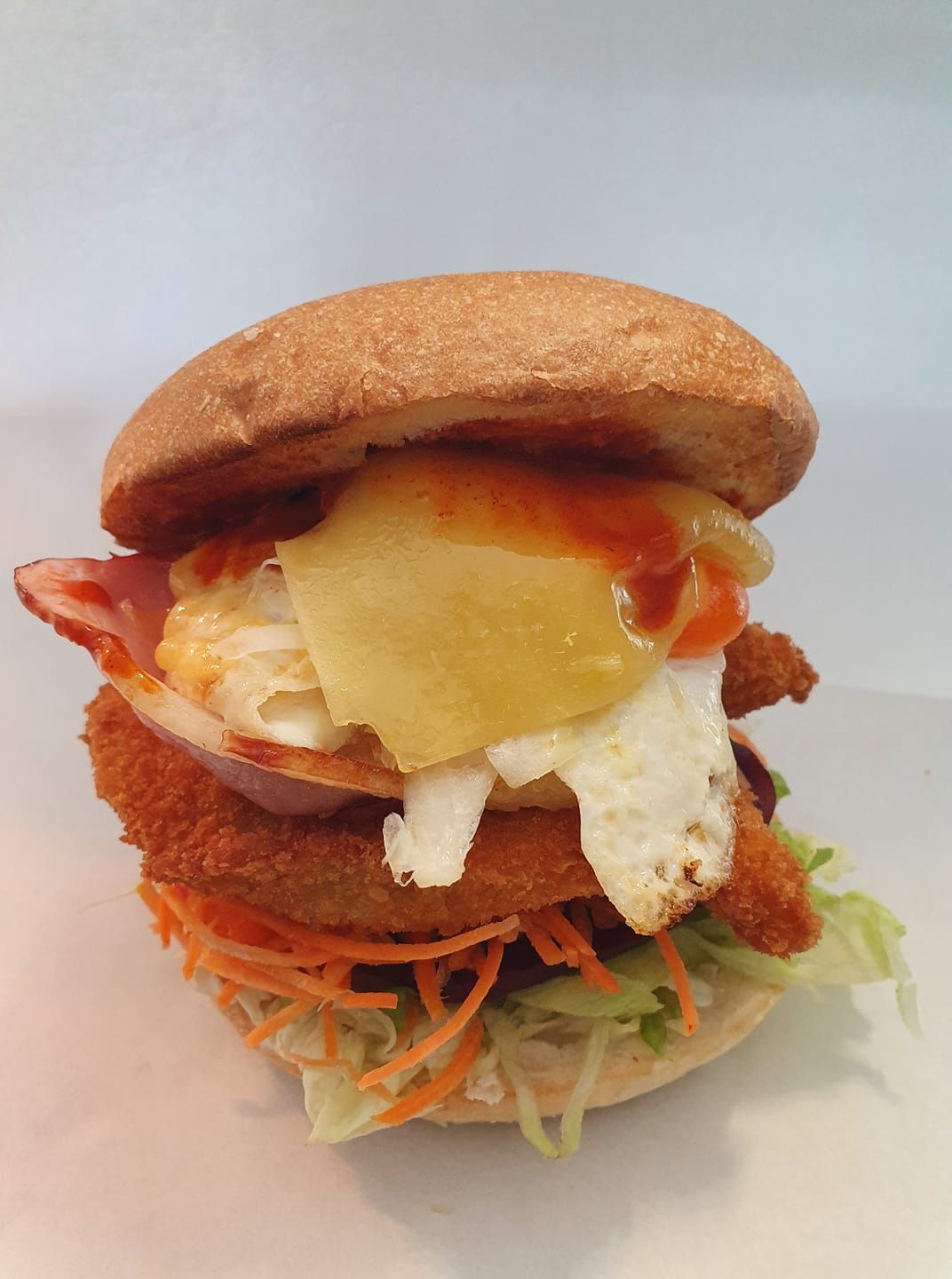 Burger with Fried Chicken, Egg, Pineapple and Sauce — Mount Louisa Snack Bar in Mount Louisa, QLD