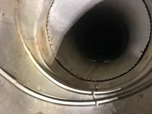 A close up of a metal pipe with a hole in the middle.