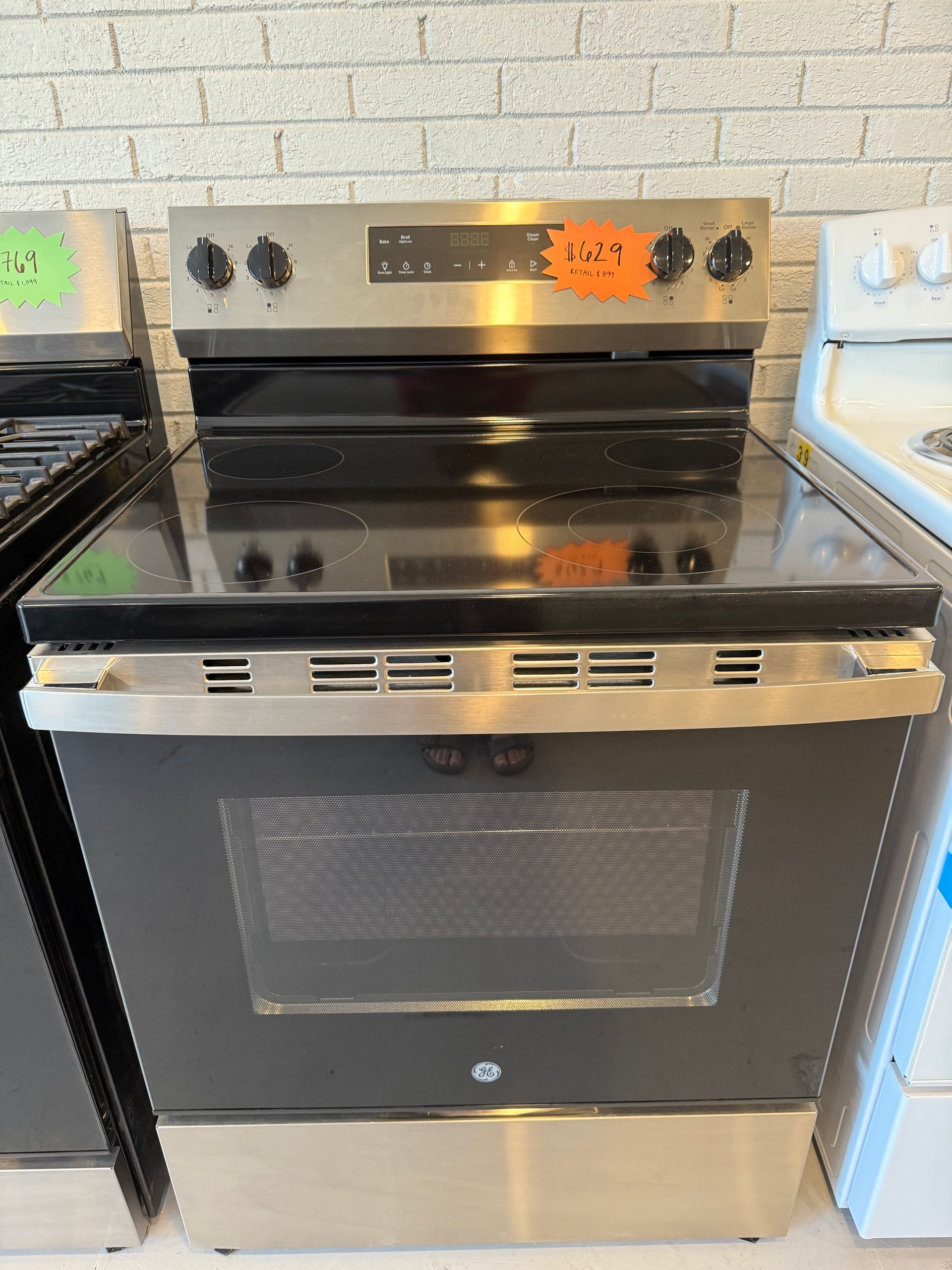 A stainless steel stove top oven with a price tag on it.