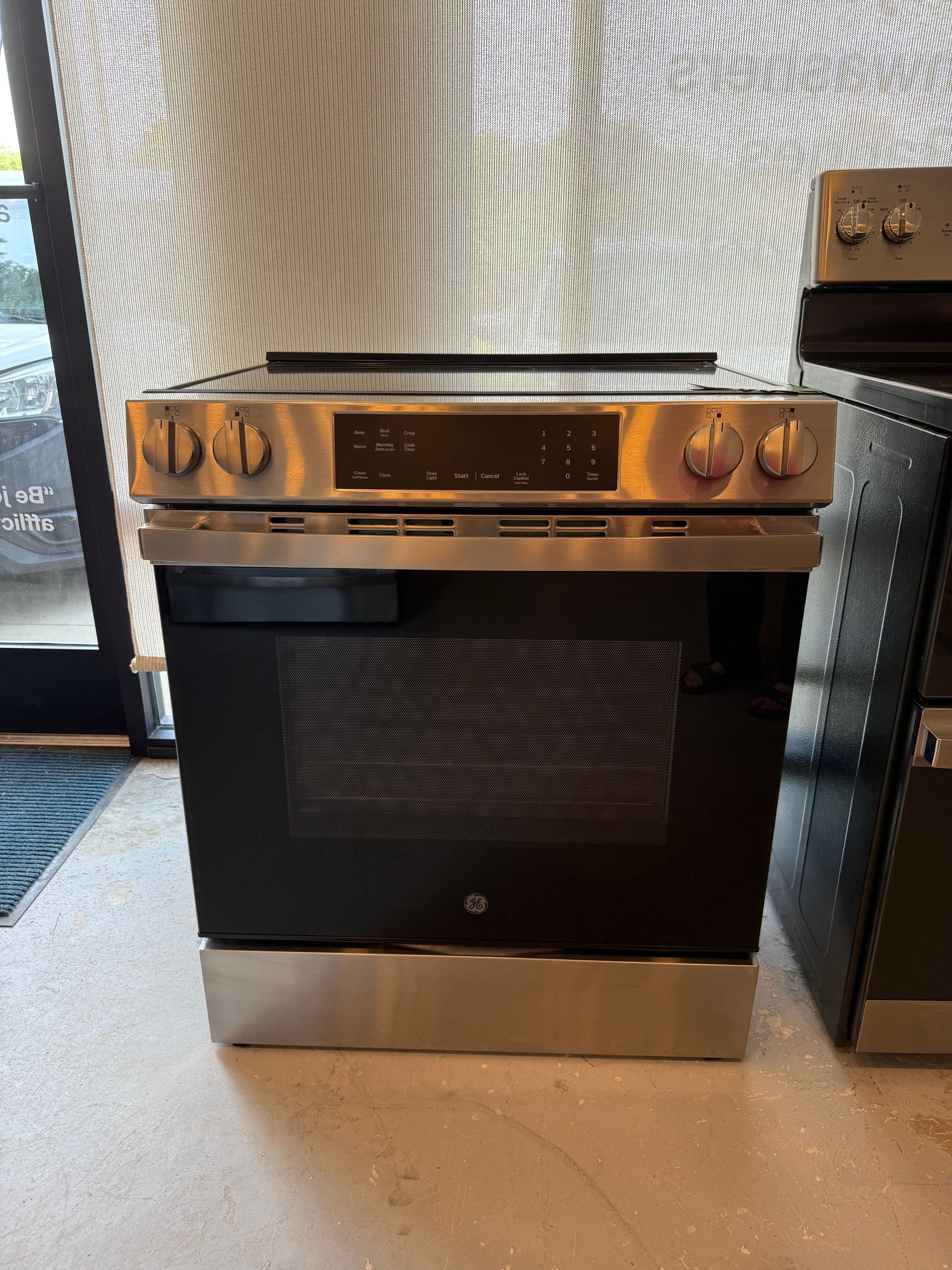 A stainless steel stove top oven is sitting on a counter in a kitchen.