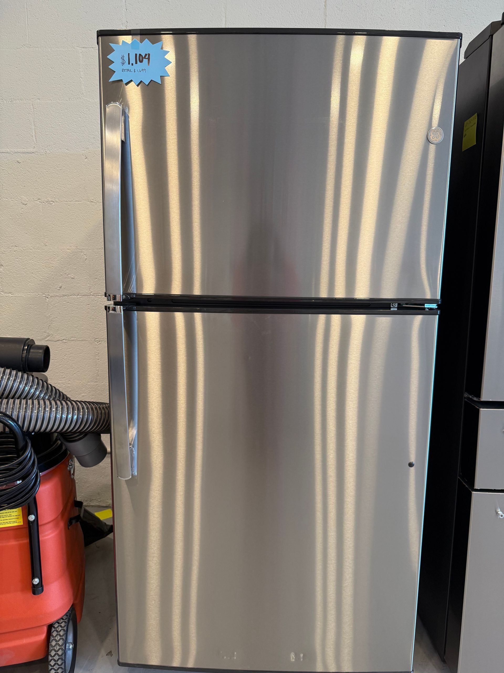 A stainless steel refrigerator with a sticker on the door that says jim