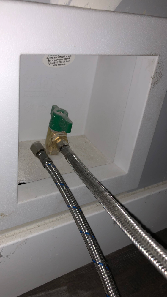 A close up of two hose connected to a washer and dryer.