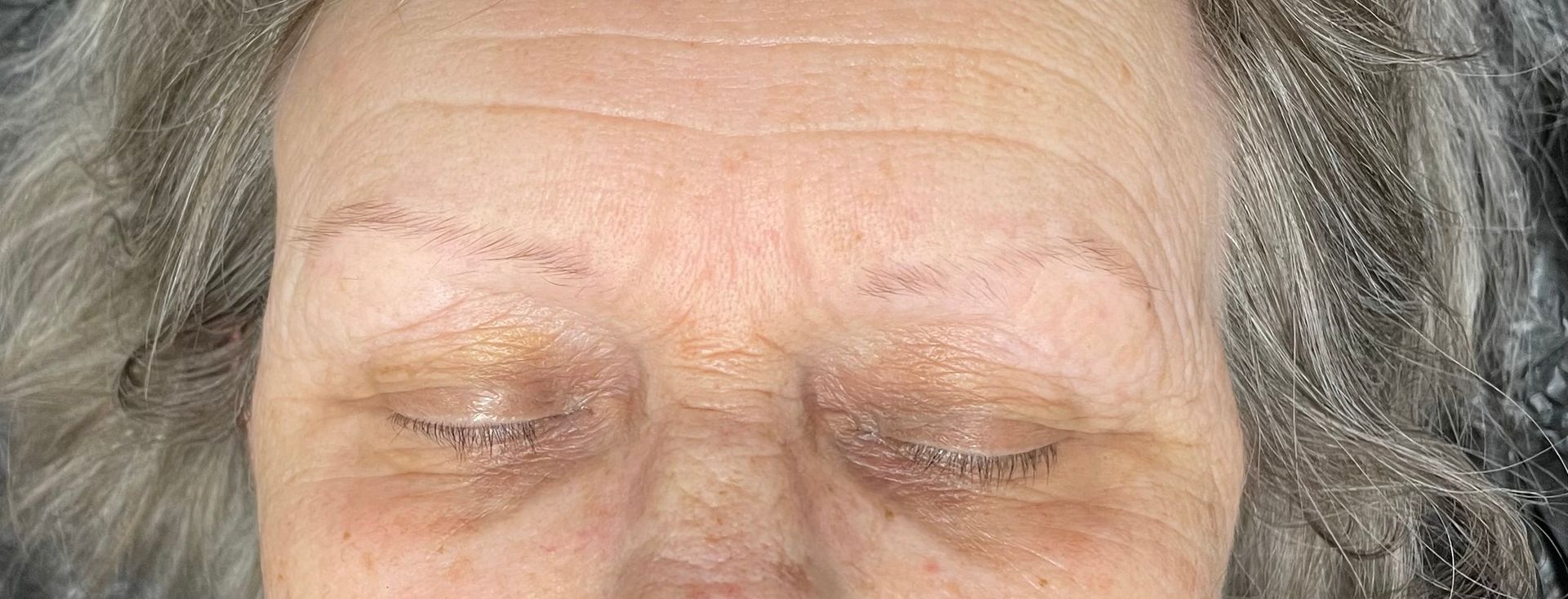 Nahaufnahme des Gesichts einer älteren Frau mit geschlossenen Augen .