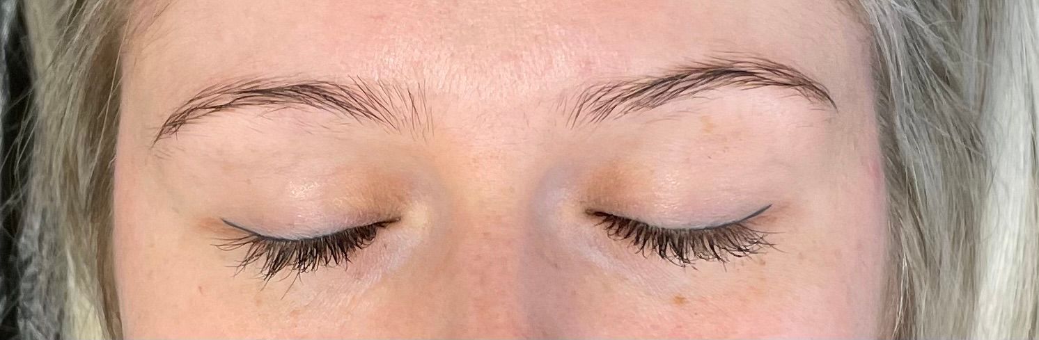 eine Nahaufnahme einer Frau mit geschlossenen Augen und langen Wimpern .