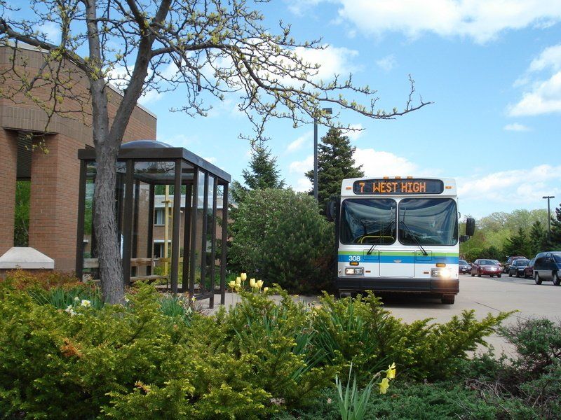 Oshkosh Route 7 bus arriving at a bus stop.