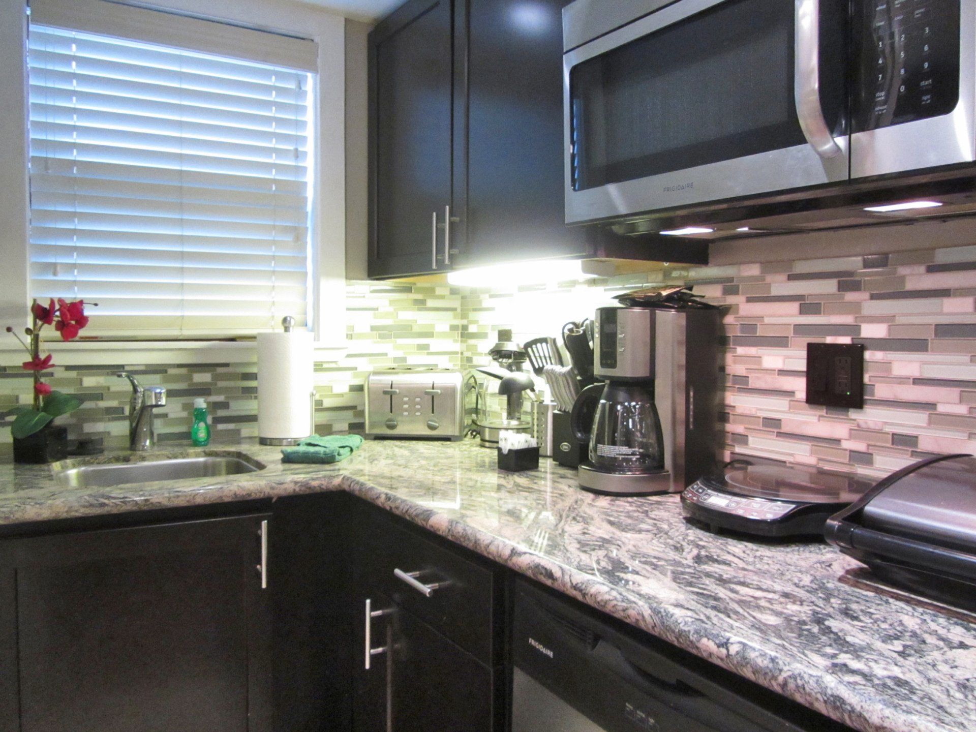 A kitchen with granite counter tops and stainless steel appliances