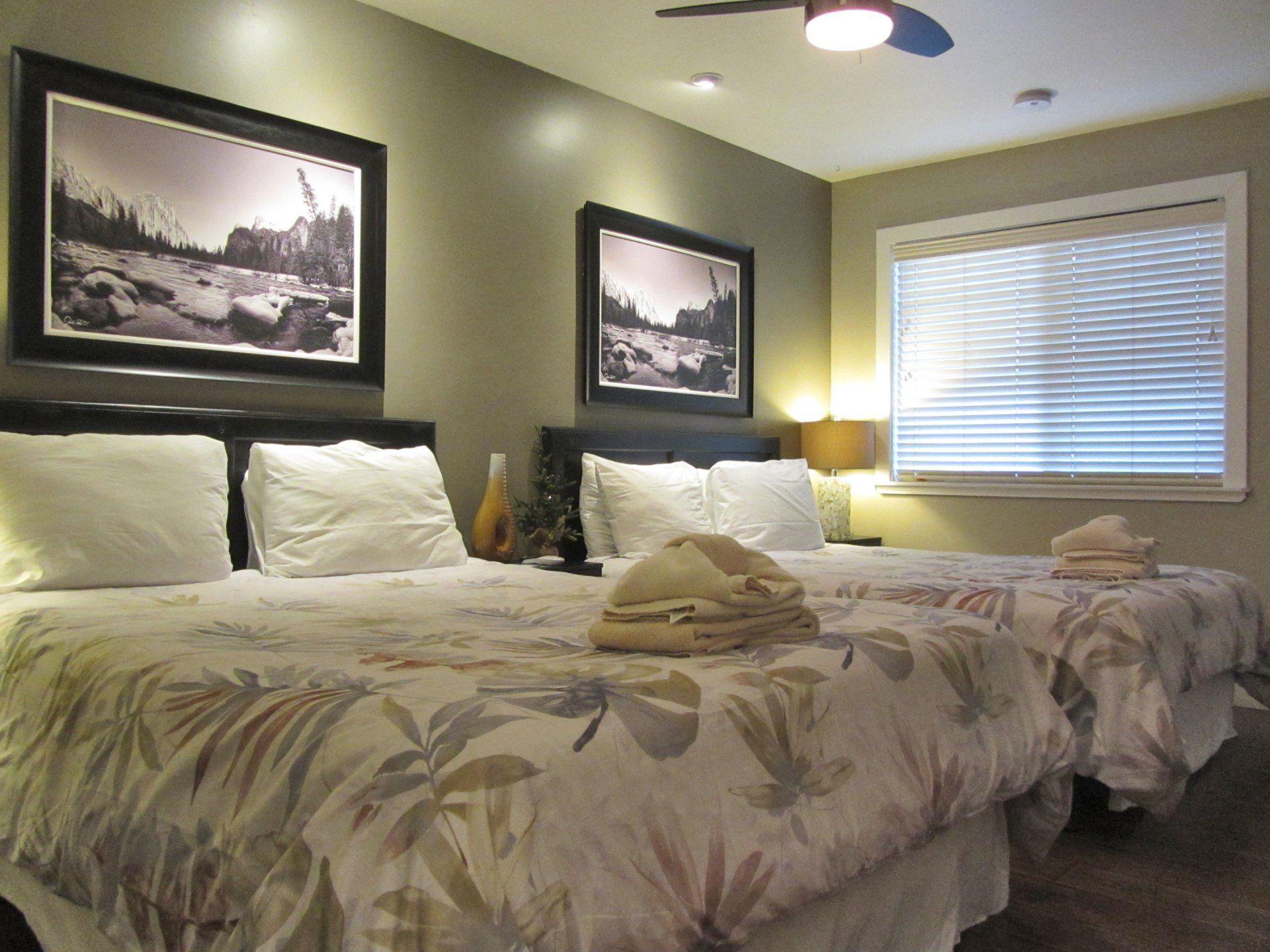 A hotel room with two beds and a ceiling fan