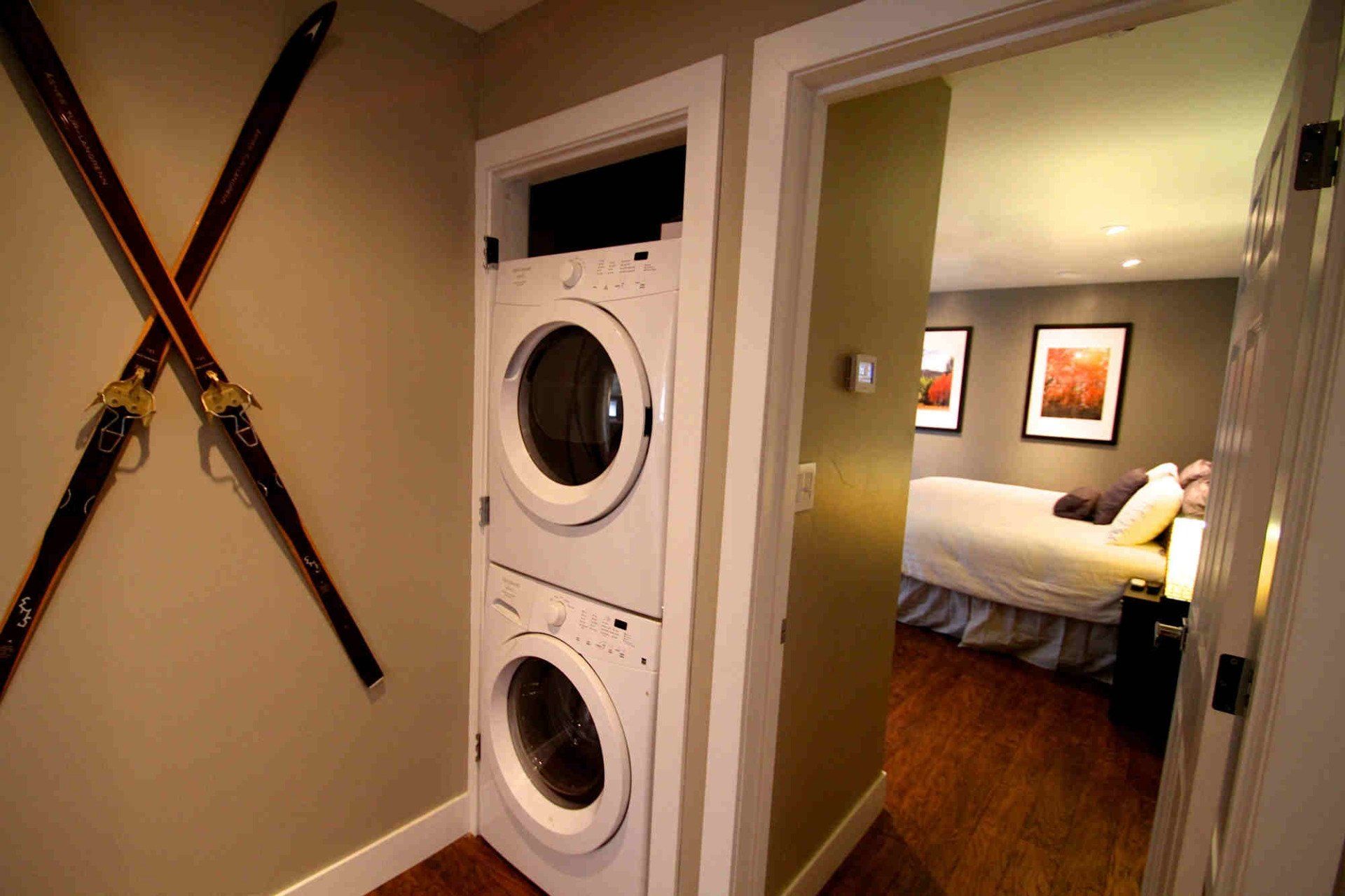 A washer and dryer are stacked on top of each other in a laundry room.