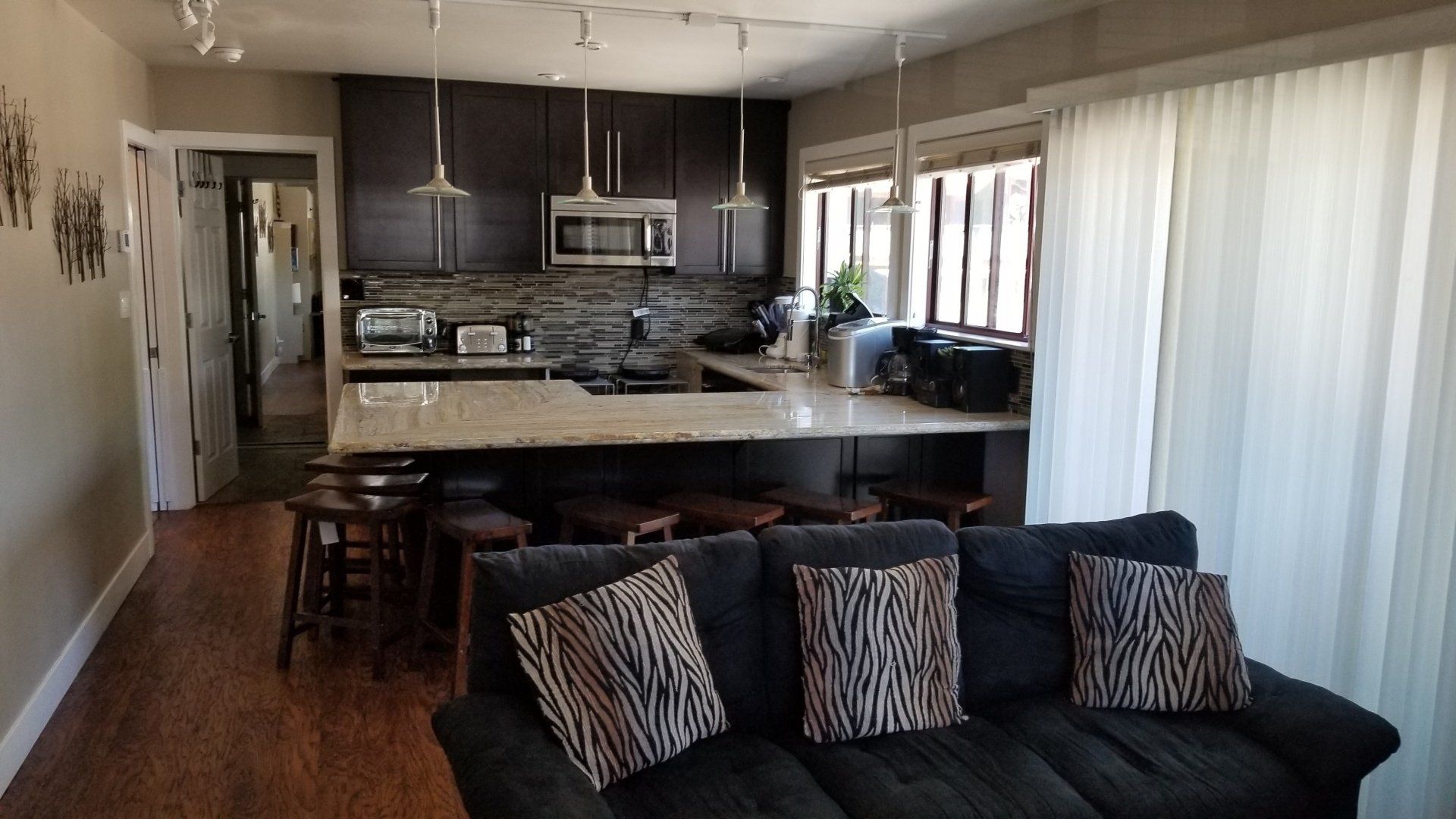 A living room with a couch and a kitchen in the background