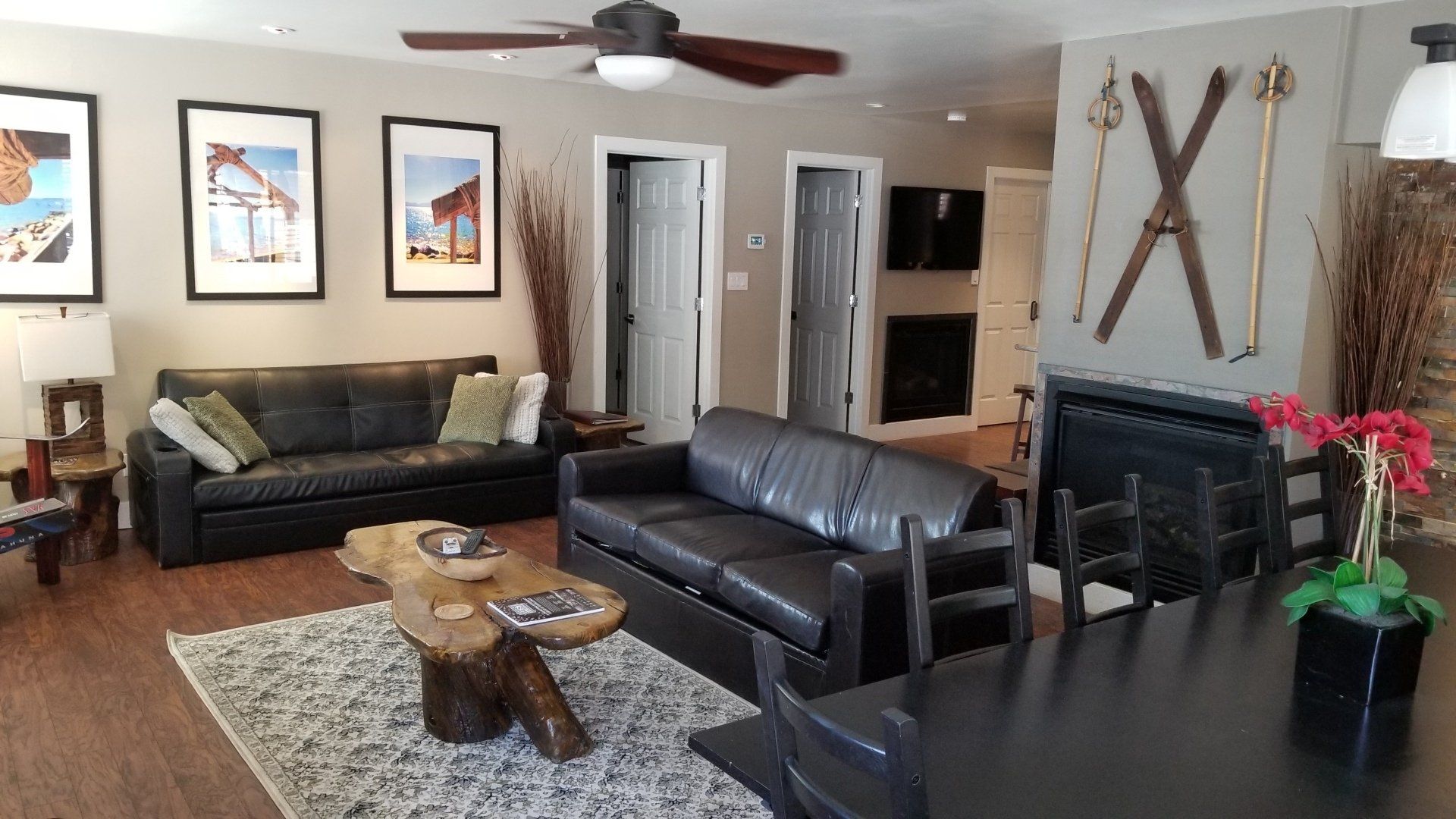A living room with a couch a table and skis on the wall