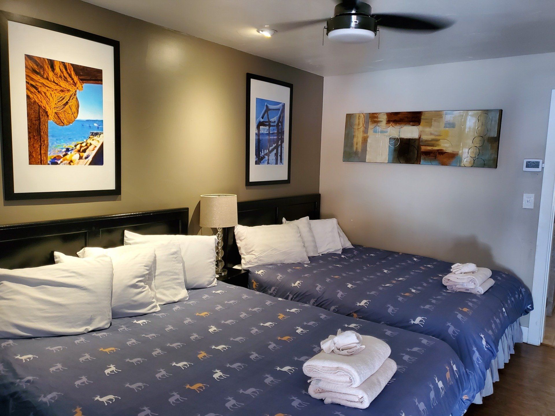 A hotel room with two beds and a ceiling fan.