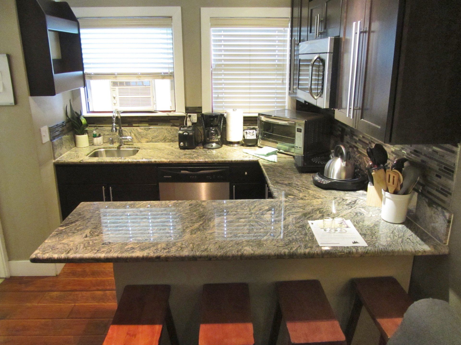 A kitchen with granite counter tops and stools