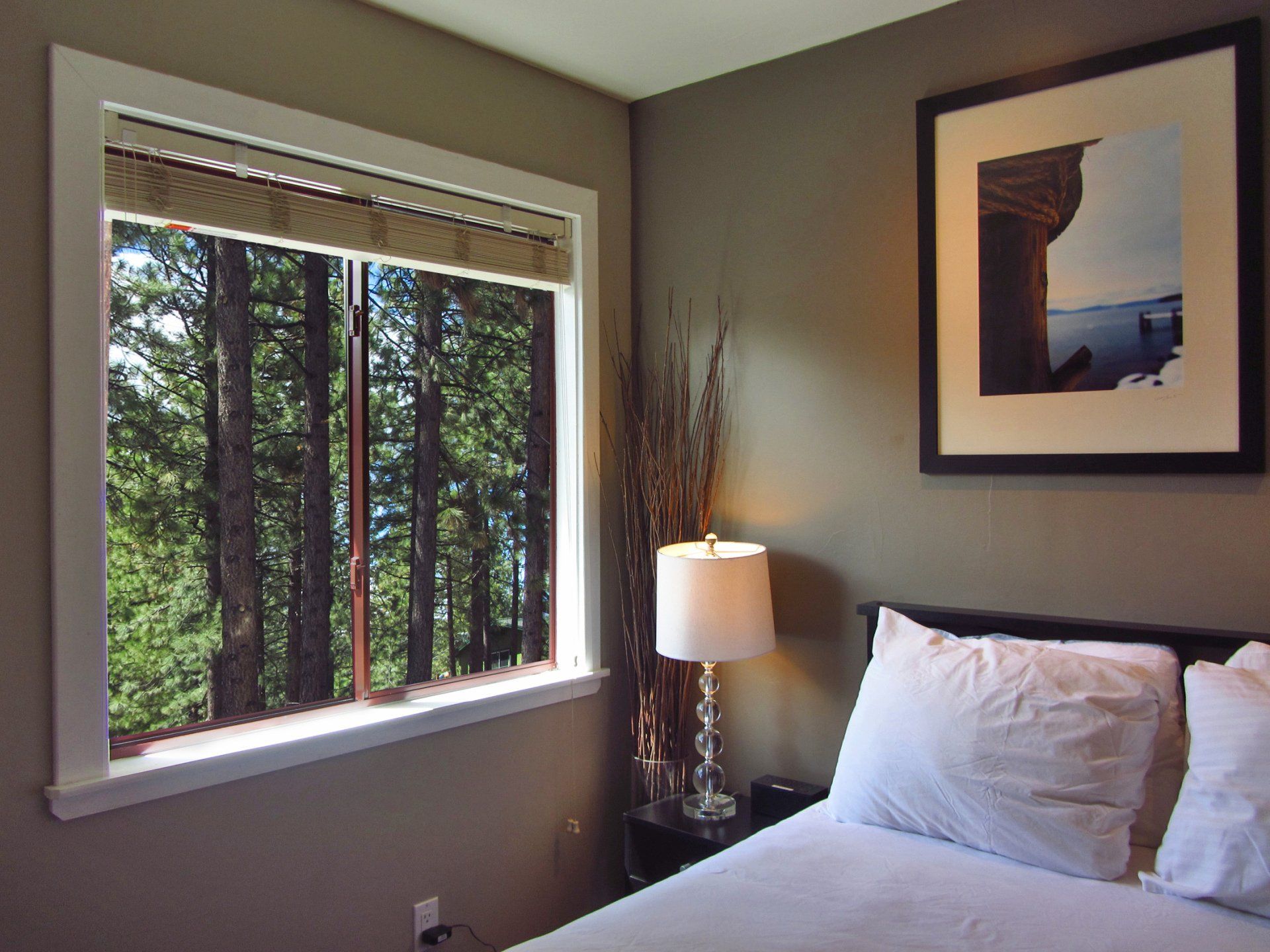 A bedroom with a bed and a picture on the wall