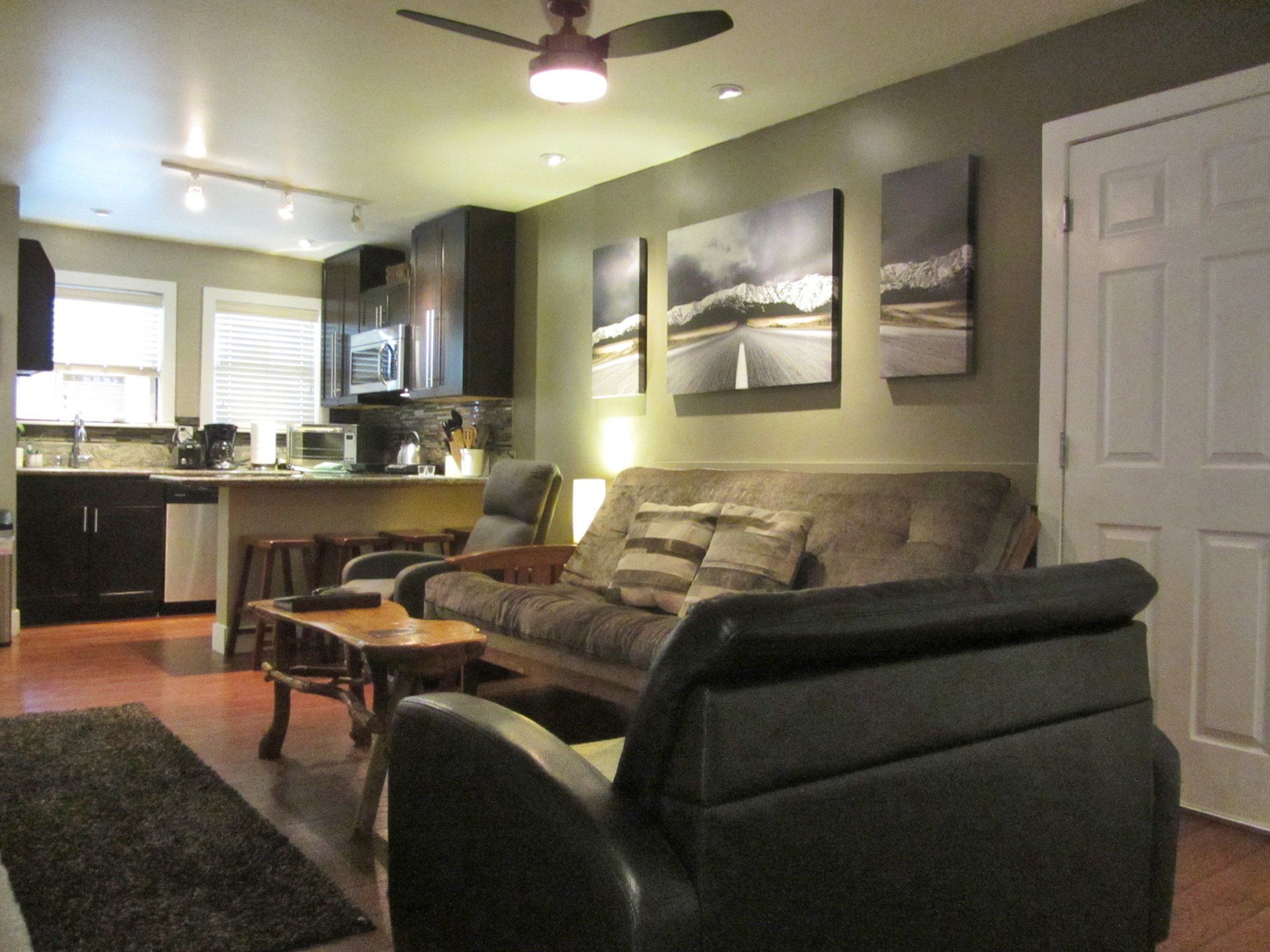 A living room with a couch and chairs and a ceiling fan