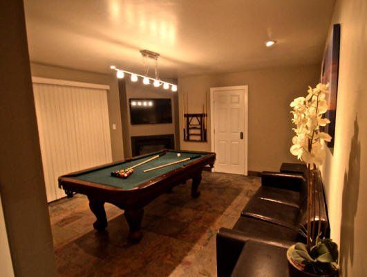 A game room with a pool table and a couch