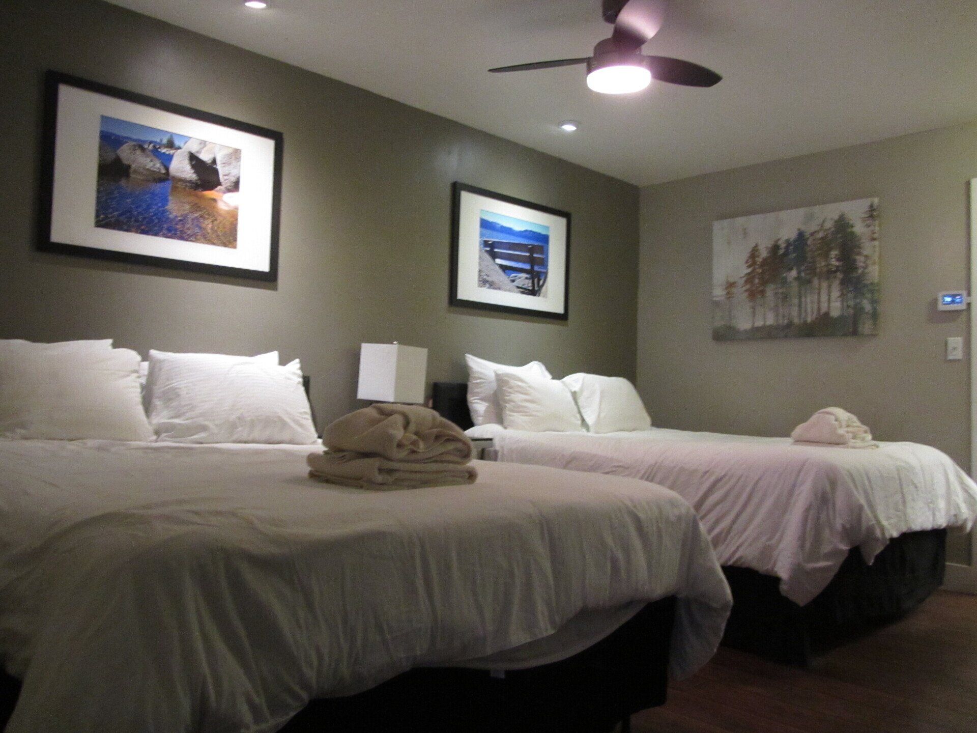 A hotel room with two beds and a ceiling fan