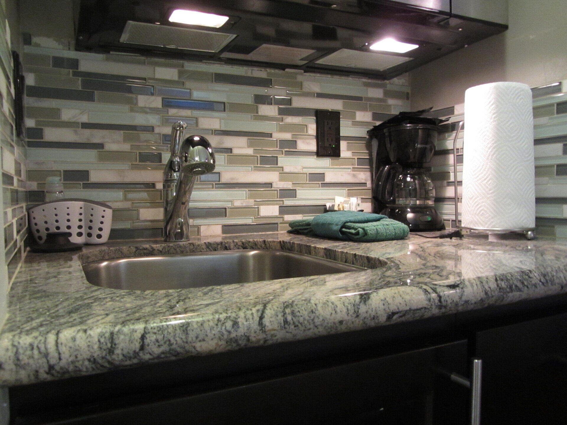 A kitchen with a sink and a paper towel holder